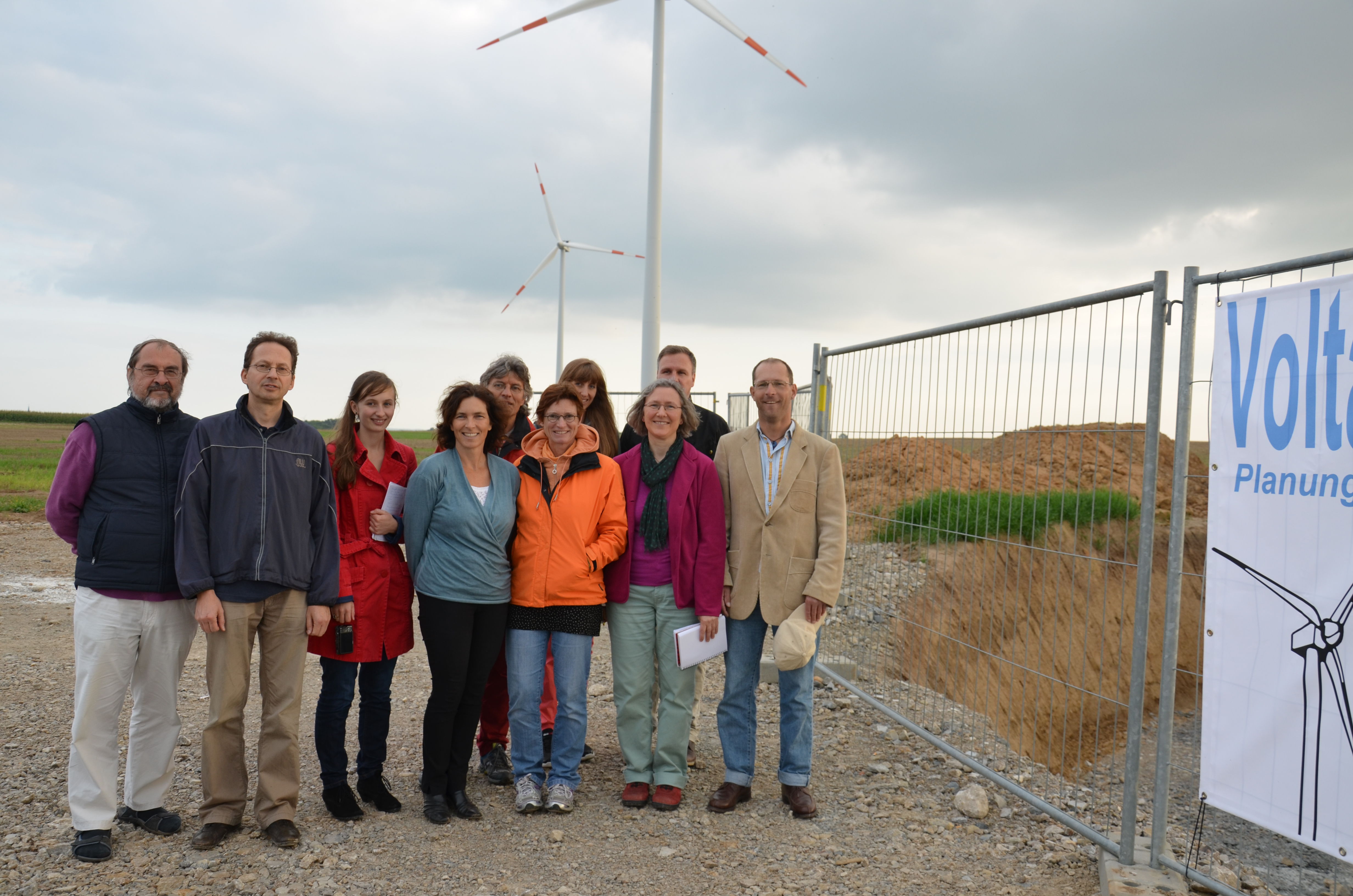 Die Grüne Besuchergruppe vor zwei Windrädern der Volta GmbH